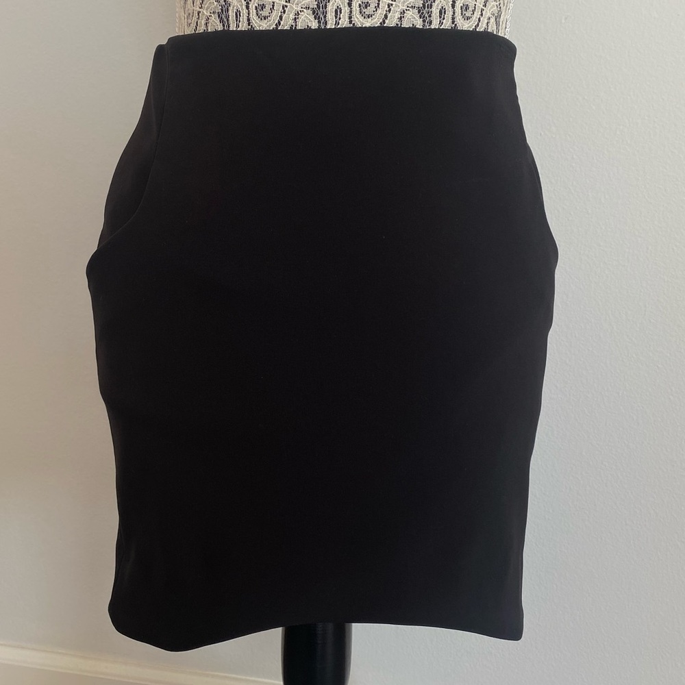 Black mini skirt wiith wave shaped hemming and pockets